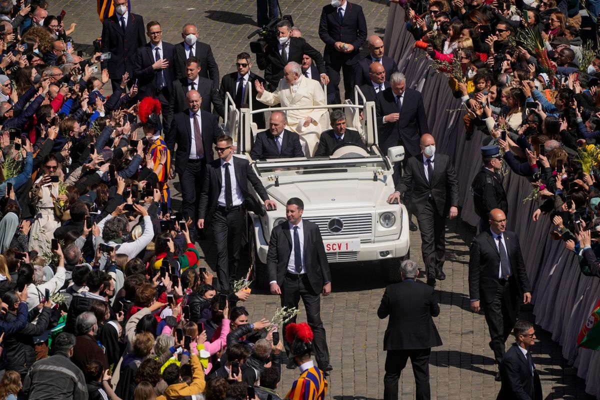 Pope Francis greets the faithful as he leaves after celebrating Palm Sunday Mass in St. Peter