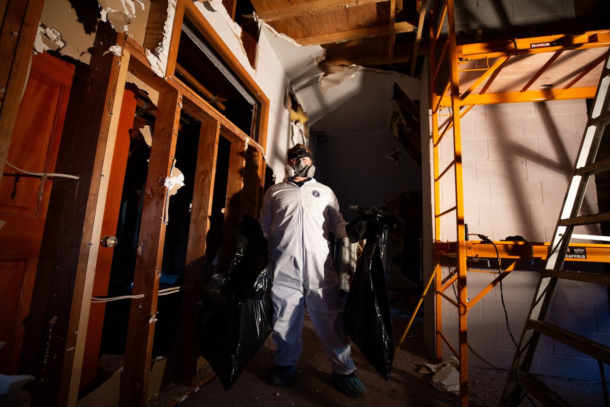 Tom Riecken holds two full trash bags of guano and drywall.  (TK)