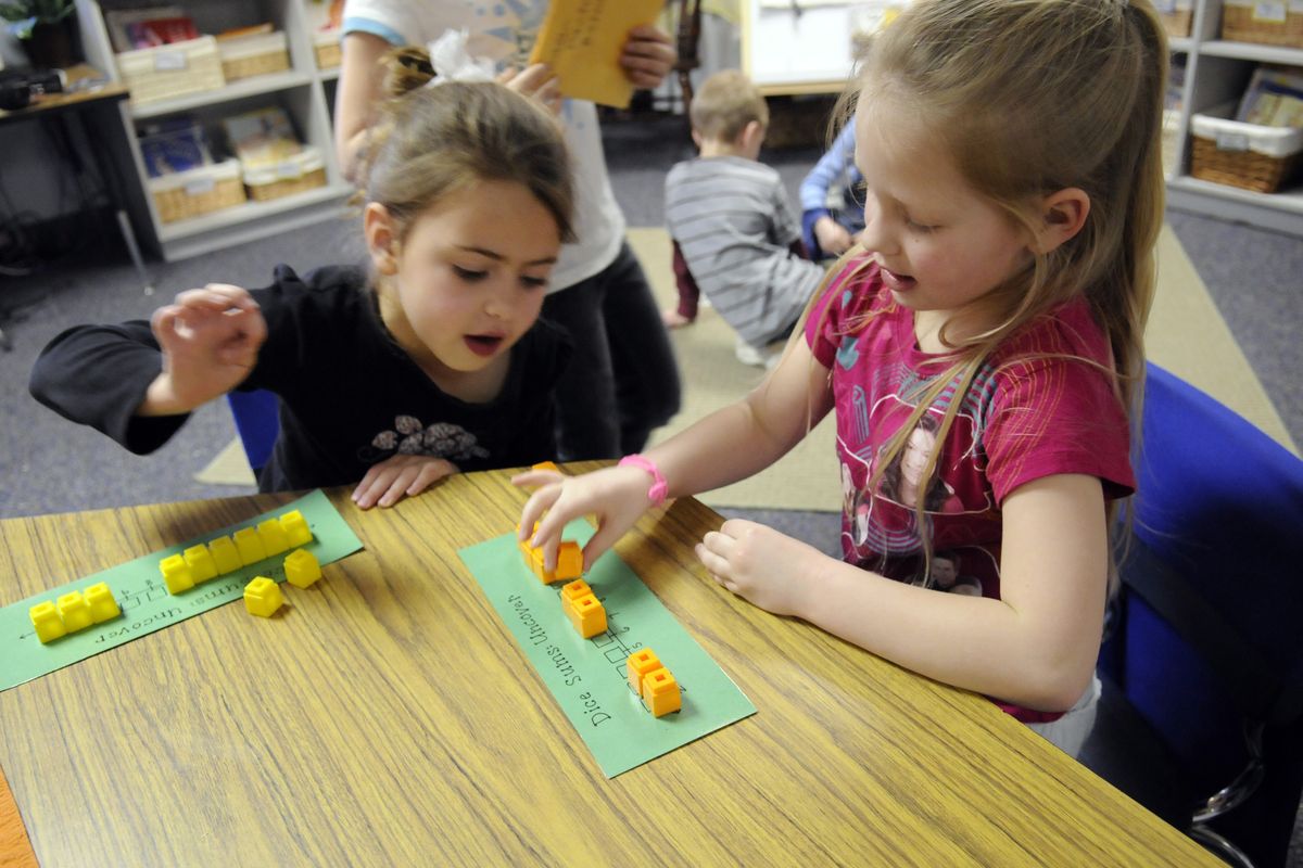 Progress Elementary School first-graders  Abby Duncan and Makala Beyers play a game of Dice Sums Uncovered during  Math Games Night Feb. 17. (J. BART RAYNIAK)