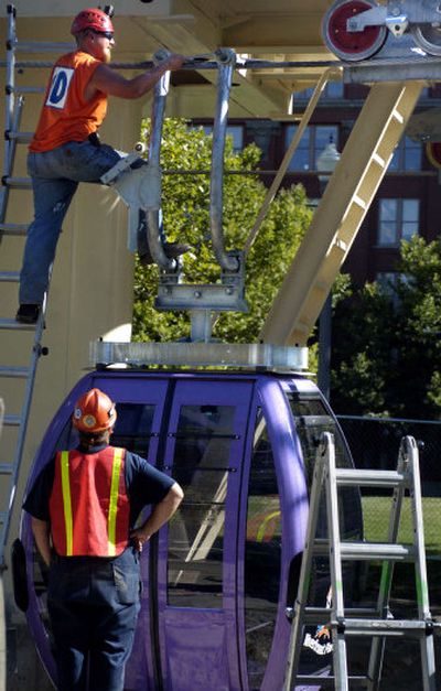 
Construction supervisor Erik Roslund attaches a gondola to cables Tuesday in Riverfront Park.
 (Holly Pickett / The Spokesman-Review)