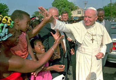 
Pope John Paul II greets Kingston, Jamaica, residents as he enters the Holy Trinity Cathedral in 1993. The pope's extensive travels helped Catholicism thrive in the developing world, raising speculation that John Paul's successor may come from Africa or South America. 
 (Associated Press / The Spokesman-Review)