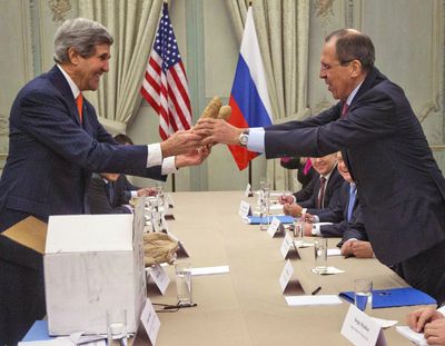 U.S. Secretary of State John Kerry, left, gives a pair of Idaho potatoes as a gift to Russian Foreign Minister Sergey Lavrov on Monday. (Associated Press)
