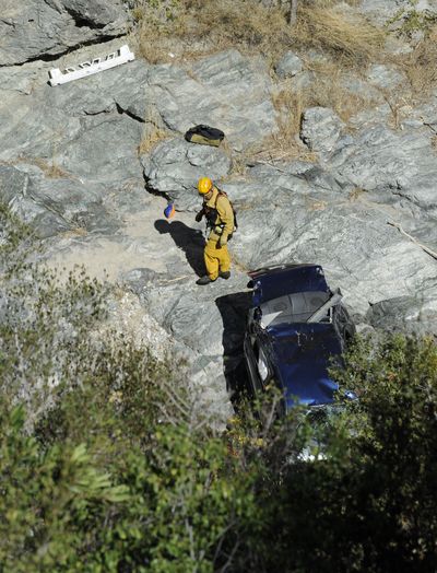 The car of a man who survived for six days after his car plunged 200 feet off a canyon road is recovered near Castaic, Calif., on Friday. (Associated Press)