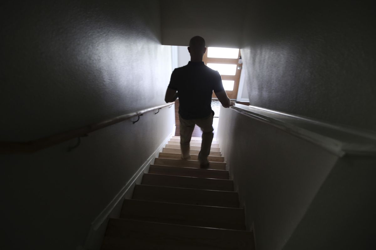 In this Aug. 8, 2017 photo, a case worker at the Family Place shelter for men walks down stairs in Dallas. The Texas group has opened what