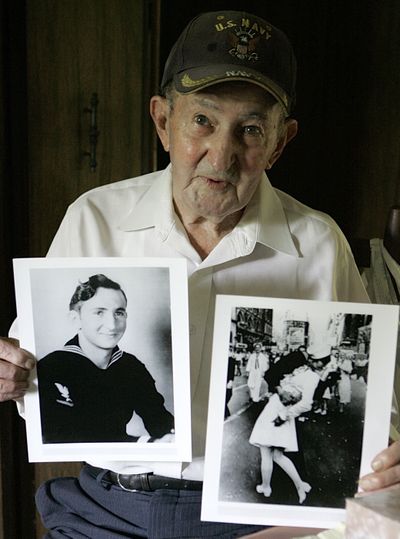 In this 2007 photo, Glenn McDuffie holds a portrait of himself as a young man, left, and a copy of Alfred Eisenstaedt’s iconic Life magazine shot of a sailor, who McDuffie claims is him, embracing a nurse in a white uniform in New York’s Times Square. (Associated Press)