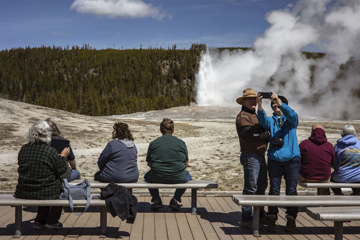 Tourists watch Old Faithful erupt in Yellowstone National Park on Thursday, April 29, 2021, in Wyoming. During Yellowstone