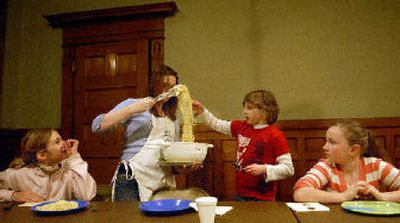 
Hana Brothers, far left, and Sophie Schwab, far right, wait  while Kyra Clossin, standing, helps Spokane Parks and Recreation instructor, Brittany Leland, dish up spaghetti noodles at a cooking class at the Corbin Art Center. 
 (Ingrid Lindemann / The Spokesman-Review)