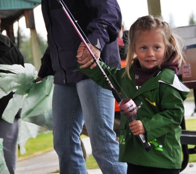 After receiving her free fishing rod, Kylee Hahn, 4, of Cheney wastes no time hauling her mom out to the beach at Clear Lake to try her hand at catching trout during the annual Kids Fish-In on May 1.  About 80 volunteers helped around 900 kids get outfitted to catch fish during the annual event sponsored by local fishing clubs, Zebco, the Washington Department of Fish and Wildlife and Fairchild Air Force Base.     (Rich Landers)