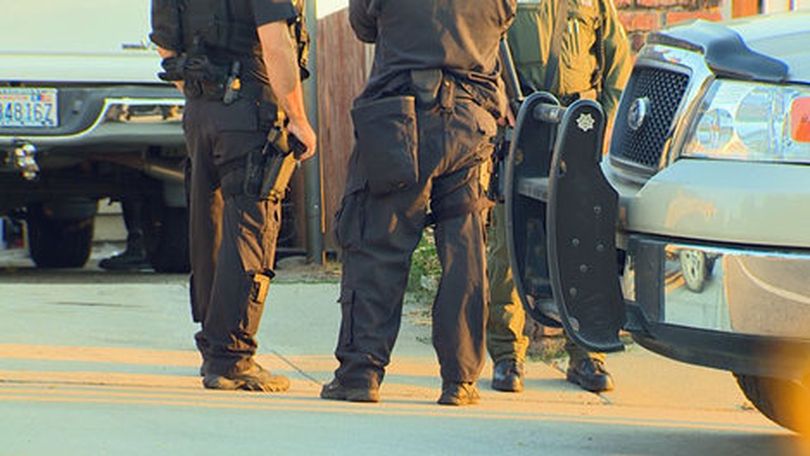 Officers gather outside a Tacoma residence on Sept. 18 where warrants were served targeting an alleged wildlife poaching operation.  (KING 5 News)