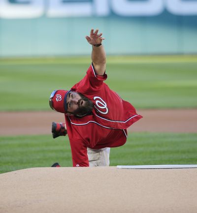 U.S. Army Sgt. 1st Class Brian Keaton mimics a grenade toss for the ceremonial first pitch before Game 2 of baseball’s NL Division Series between the Washington Nationals and the San Francisco Giants. (Associated Press)