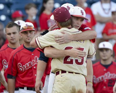 Florida State’s James Ramsey (23) hugs Stony Brooks’ Tyler Johnson after an NCAA College World Series elimination game. (Associated Press)