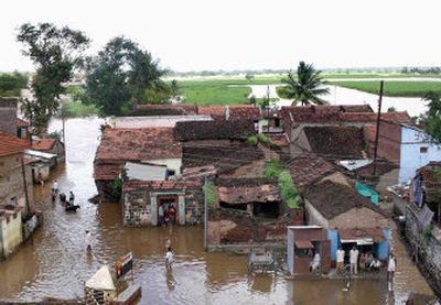 
People wade through flood water in Dudhgaon, about 350 miles southwest of Bombay, India, on Saturday. The discovery of more bodies pushed the death toll from monsoon flooding in India to 853 on Saturday. 
 (Associated Press / The Spokesman-Review)