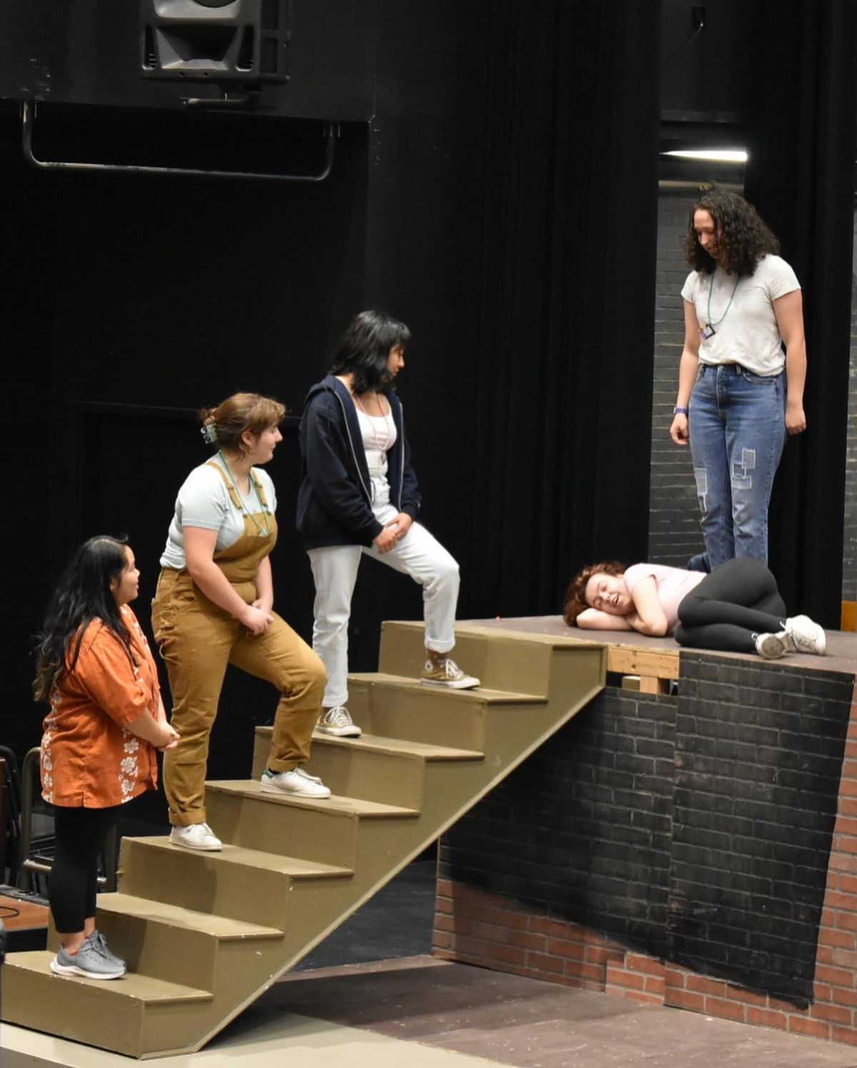 Titania (Lizzie Hall) prepares to sleep, tended to by the fairy court of Cobweb (Vina Lie), Mustardseed (Kelly Hewitt), Moth (Diana Ramirez-Leon), and Peaseblossom (Anya Droppo).  (Clara Buck)