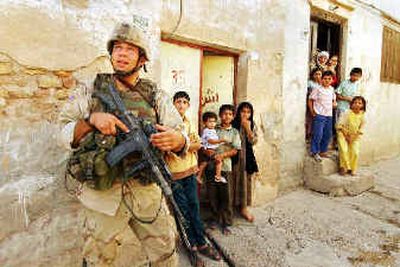 
Iraqi children watch a U.S. Army soldier on patrol in Samarra on Wednesday, five days after U.S. and Iraqi forces launched a major incursion into the city
 (Associated Press / The Spokesman-Review)
