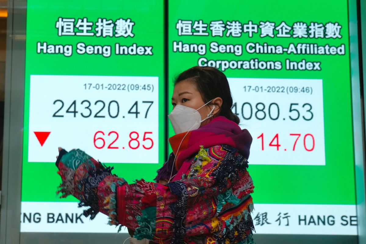 A woman wearing a face mask walks past a bank