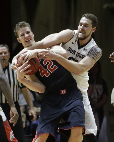 Utah’s Jakob Poeltl, left, fights for a loose ball against Arizona State’s Eric Jacobsen in the first half. (Associated Press)