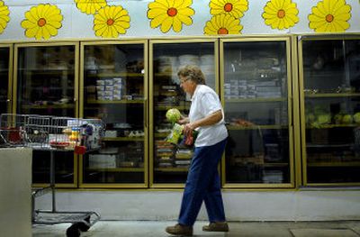 
Post Falls Food Bank volunteer Maxine Nelson fills a cart for pickup later in the day. The food bank just celebrated its 20th anniversary. 
 (Kathy Plonka / The Spokesman-Review)