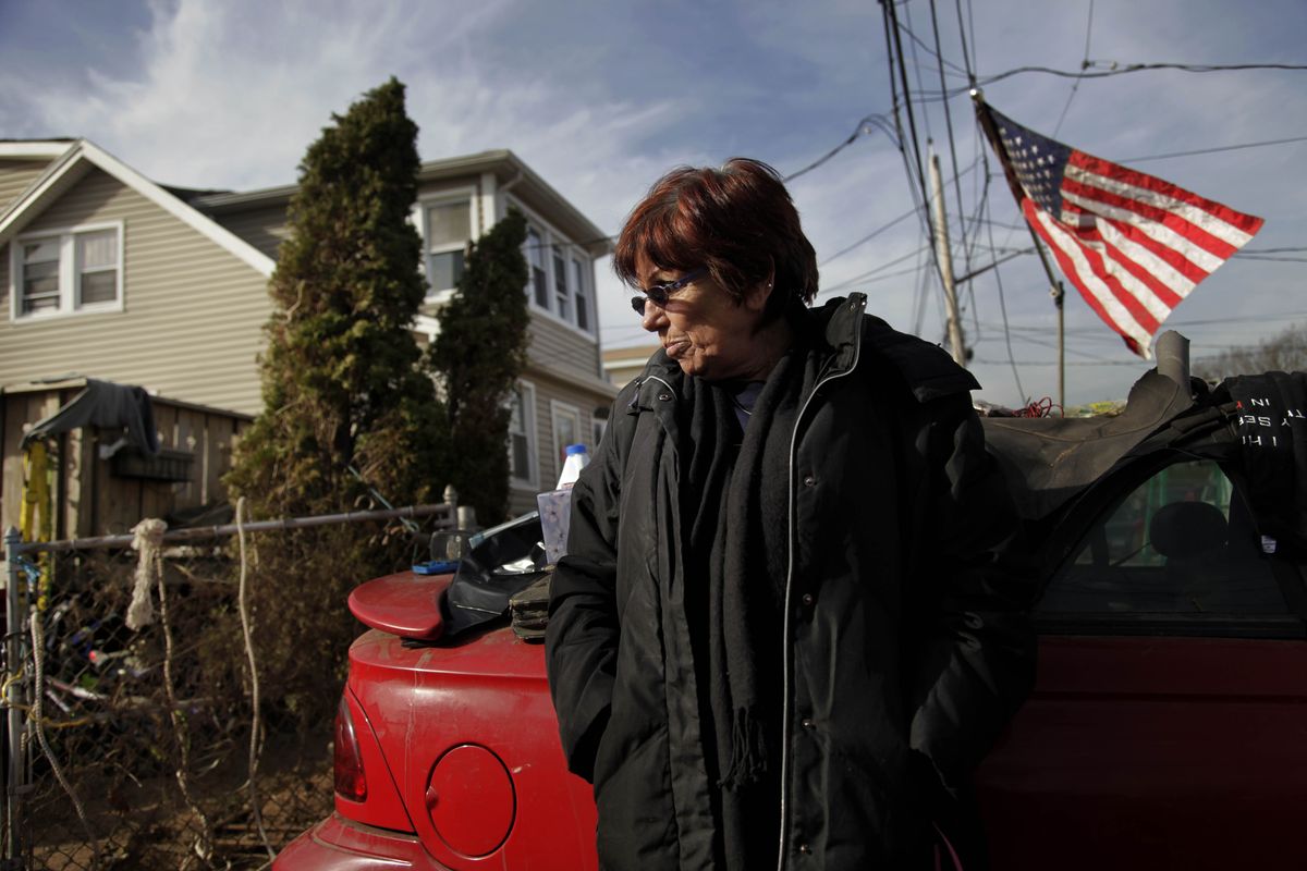 In this Tuesday, Nov. 20, 2012 photo, Marge Gatti stands in front of her home, which was damaged by Superstorm Sandy, in the Midland Beach section of the Staten Island borough of New York. Of all things material, Gatti has nothing. And yet, on Thanksgiving Day, she will be counting her blessings this year. �My sons are alive. They were trapped here,� says Gatti, 67, who lived in this beige-colored home down the block from the Atlantic Ocean for 32 years. (Seth Wenig / Associated Press)