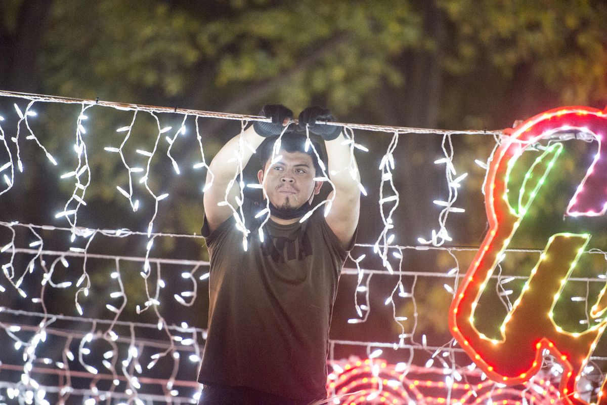 A worker puts the finishing touches on the new Christmas light display set up courtesy of Netflix in downtown Augusta, Ga., Wednesday Dec. 9, 2020. The display includes lights of different colors and signs promoting Netflix Christmas movies and shows. Six cities, including Augusta, were selected. (Michael Holahan)