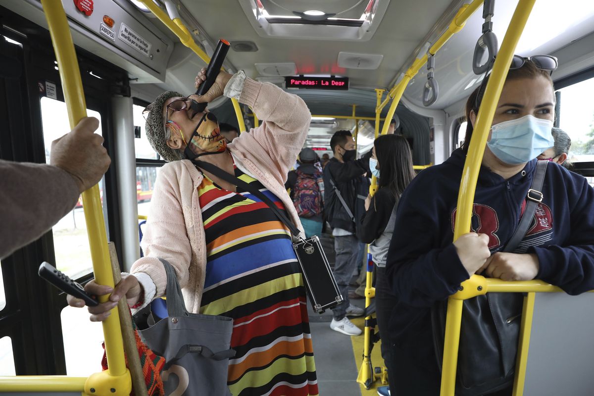 Marlene Alfonso, a 69-year-old Venezuelan grandmother who goes by the name “Toothless Cindy,” sings Tuesday about Venezuelan migrants’ on the Transmilenio, the crowded and crime-ridden public bus system in Bogota, Colombia. She performs in hopes of collecting tips from commuters.  (Fernando Vergara)