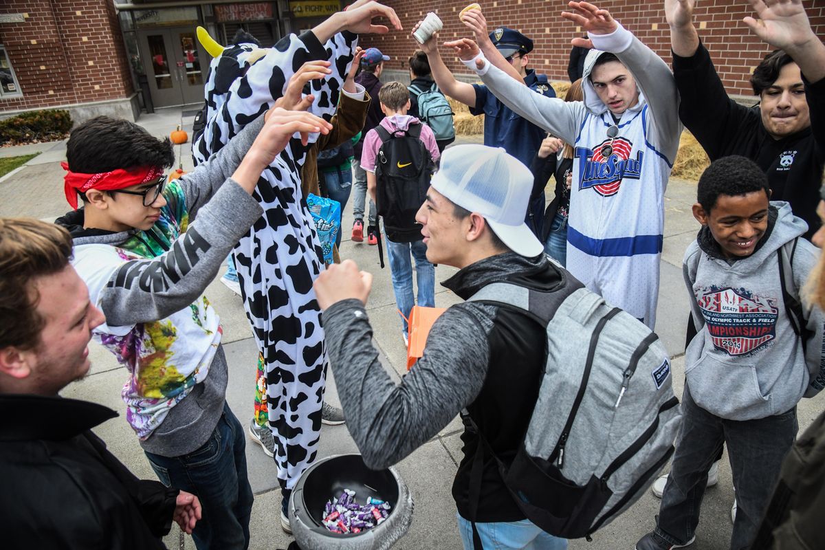 University High School senior Zach Granly, center in white hat, proceeds through the tunnel of arms formed by students welcoming fellow Titans to school, Thursday, Oct. 25, 2018, in Spokane Valley, Wash. (Dan Pelle / The Spokesman-Review)