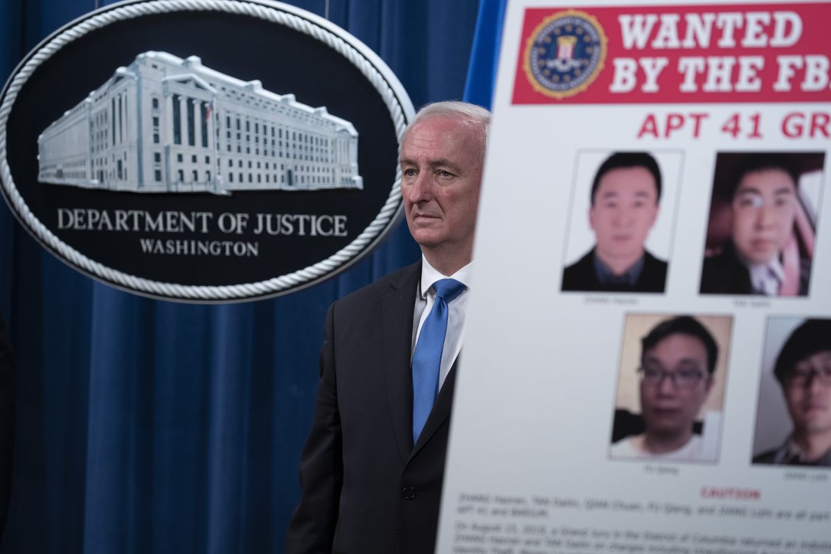 Deputy Attorney General Jeffery Rosen listens, Wednesday, Sept. 16, 2020 at the Justice Department in Washington. The Justice Department has charged five Chinese citizens with hacks targeting more than 100 companies and institutions in the United States and abroad, including social media and video game companies as well as universities and telecommunications providers. Officials announced the prosecution on Wednesday. (Tasos Katopodis)