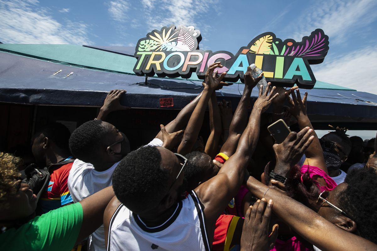 People rip a sign off a kiosk during a protest against the violent death of a Congolese immigrant earlier this week over an alleged pay dispute, in Rio de Janeiro, Brazil, Saturday, Feb. 5, 2022. The death of 24-year-old Moïse Mugenyi Kabagambe has sent shockwaves across Brazil after the assailants were caught on security camera footage attacking the young man, and over the course of 13 minutes holding him down and beating him with a rod — and continuing to do so even after he lost consciousness.  (Bruna Prado)