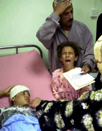 
Adlah Ghaib Alyas cries as her sister Najlah is admitted at a hospital in Mosul.  Their father Ghaib Alyas, rear, said that his wife died in the airstrike at Tal Afar, near the Syrian border. The U.S. military said 57 insurgents were killed in the attack. 
 (Associated Press / The Spokesman-Review)