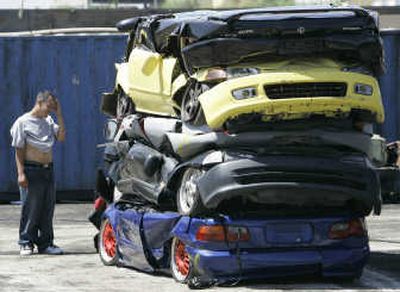 
Manuel Hernandez reacts after his car and other impounded vehicles were crushed Wednesday at the Ecology Auto Parts in Rialto, Calif.,  as part of a crackdown on illegal street racing.Associated Press
 (Associated Press / The Spokesman-Review)