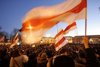 
Supporters of Belarus' opposition leader wave banned Belarusian flags on a main square in central Minsk, Belarus, on Monday. 
 (Associated Press / The Spokesman-Review)