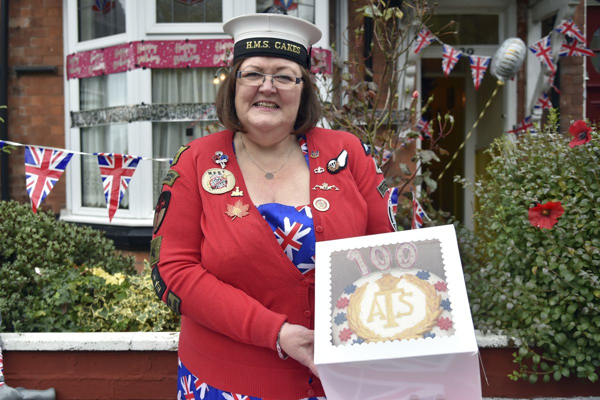Kath Ryan delivers a cake on Oct. 5 to celebrate the 100th birthday of Leonora Jeffreys, a former Doodlebug spotter during World War II in Birmingham, England. (Rui Vieira)