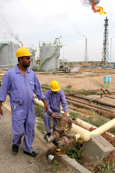 
Employees work at Sheaiba oil refinery, about 25 miles west of Basra. Iraq is likely to sign billions of dollars in foreign investment deals with some of the world's largest companies if, as expected, its new oil law is approved soon. 
 (Associated Press / The Spokesman-Review)