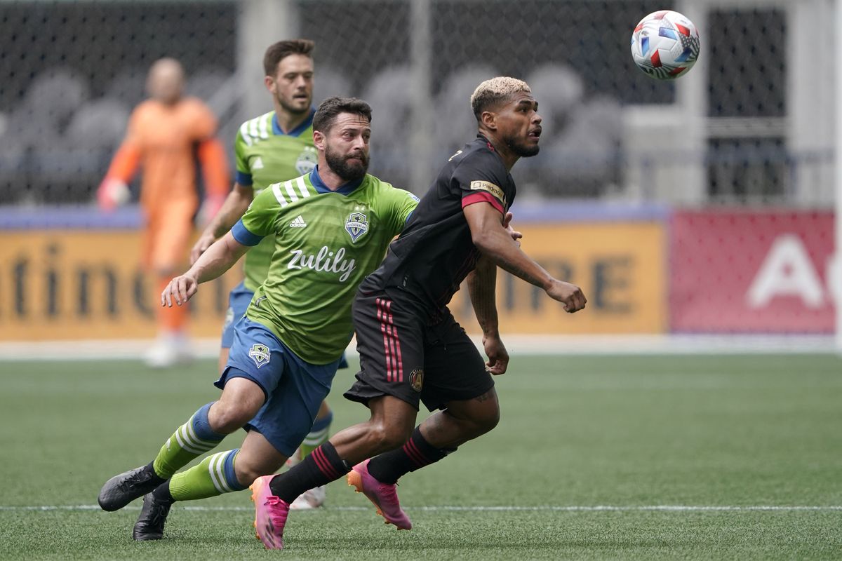 Atlanta United forward Josef Martinez, right, and Seattle Sounders midfielder Joao Paulo, center, watch the ball during the first half of an MLS soccer match, Sunday, May 23, 2021, in Seattle.  (Ted S. Warren)