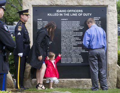 Lindy Moore, the wife of fallen Coeur d’Alene policeman Gregory K. Moore, helps remove a black ribbon revealing his name with daughter Gemma, 2 and son Dylon Moore, 13, on the Idaho Peace Officers’ Memorial Thursday Meridian, Idaho. (Darin Oswald / Associated Press)