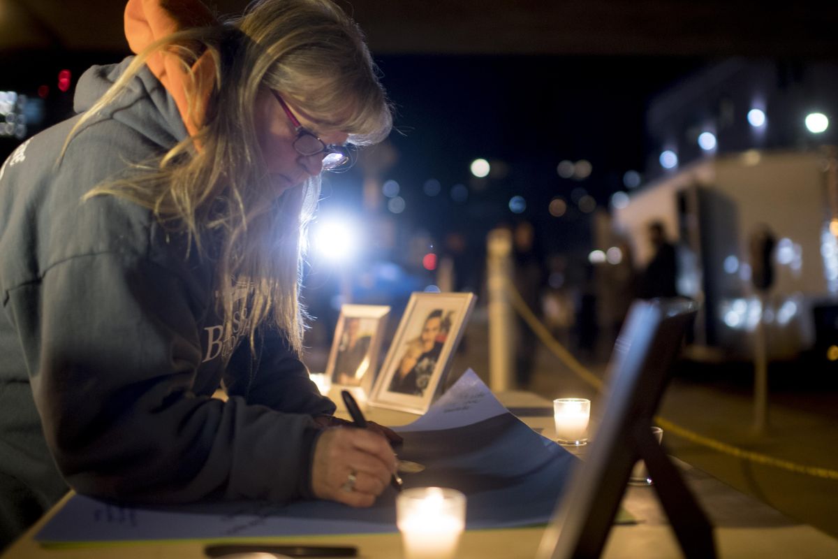 Renee Gomez, a volunteer with Blessings Under the Bridge writes a message on Wednesday, Jan. 31, 2018, in support of Clay Brock, who was severely injured and his fiancee Michele Purkey killed Friday night when struck by a car in Spokane, Wash. (Tyler Tjomsland / The Spokesman-Review)
