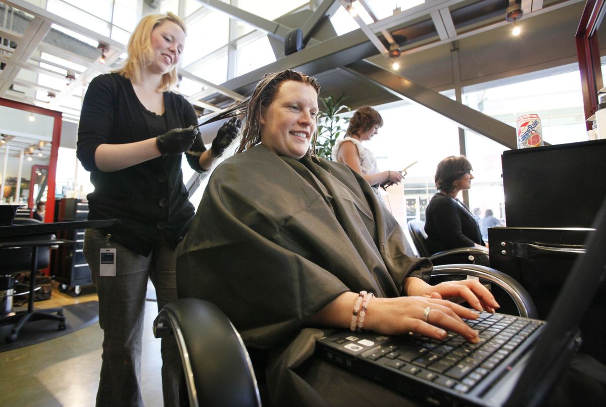 Microsoft employee Katy Flaherty works on a laptop computer as she has her hair done by Christine Golson at the Commons, a mini-mall at Microsoft’s new West Campus development in Redmond, Wash. Associated Press photos (Associated Press photos / The Spokesman-Review)
