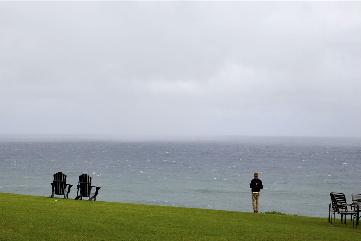 A person stands in front of the Pacific Ocean at The Cliffs at Princeville resort, one of several "resort bubble" properties on Kauai, Friday, March 5, 2021, in Princeville, Hawaii. The rural island of Kauai in Hawaii is one of the world