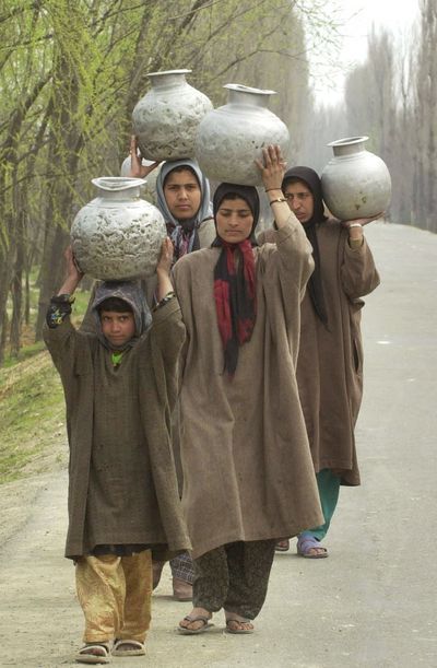 Kashmiri village women carry potable water at Pattan, 22 miles north of Srinagar, India. Many areas around the world lack the infrastructure to supply their citizens with easily accessible drinking water. (File Associated Press / The Spokesman-Review)