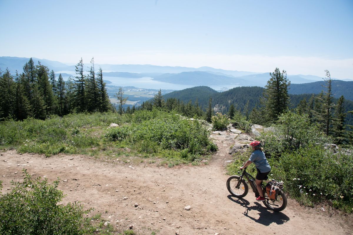 Dani Demmons rounds a corner on Schweitzer Mountain on Monday July 16, 2018 while riding a e-bike. Demmons leads Schweitzer Mountain Resort