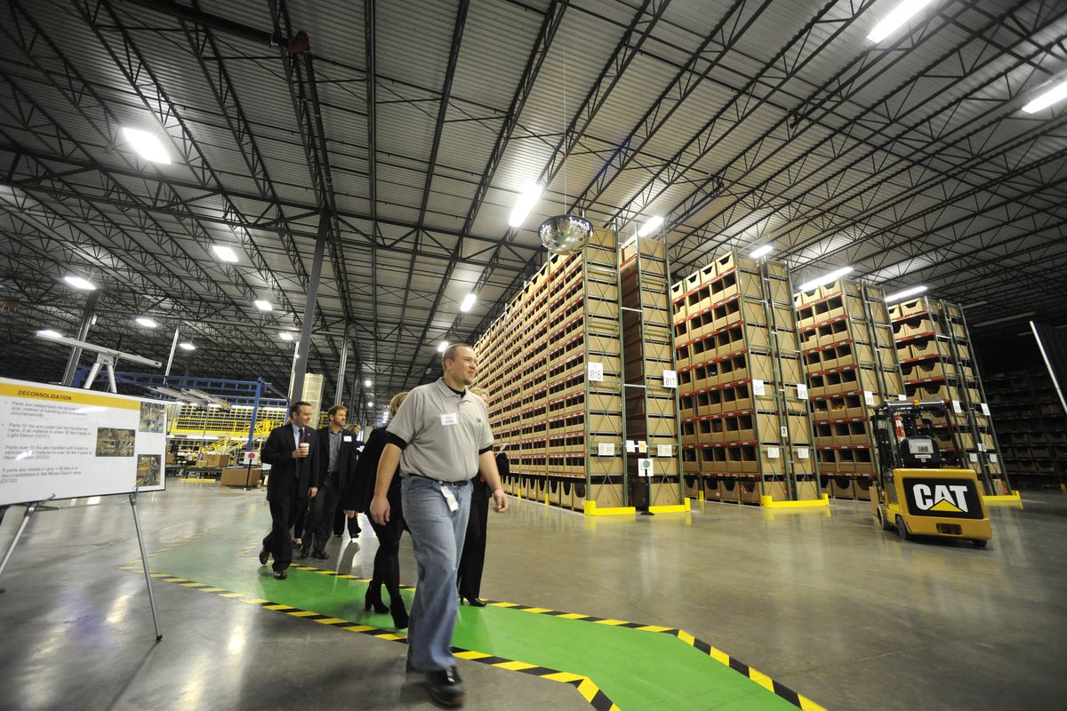 Employees and visitors walk through the new Caterpillar parts distribution center on Spokane’s West Plains on Thursday. The company held a short ceremony to cut the ribbon on the plant, which has been in limited operation since August. (Jesse Tinsley)