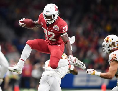 Washington State  running back James Williams  hurdles Iowa State  defensive back Brian Peavy  during the first half of the  Alamo Bowl on  Dec. 28, 2018,  in San Antonio. (Tyler Tjomsland / The Spokesman-Review)