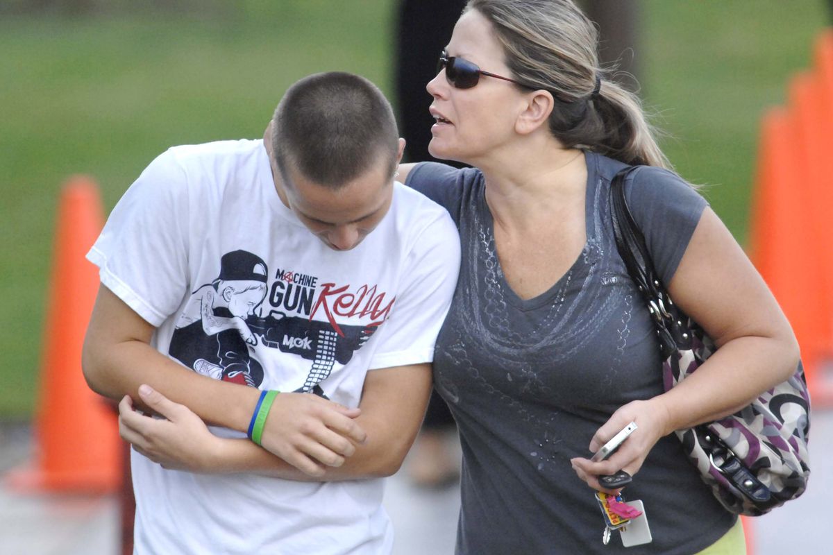 Laura Lawson hugs her son, Colegraham, 17, a senior at Normal Community High School, after they were reunited at Eastview Christian Church following gunfire at the high school, Friday, Sept. 7, 2012, in Normal, Ill. School officials say police have taken two students into custody after gun shots were fired into a ceiling inside the school. The Normal Community High School says on its website that nobody was hurt in the Friday morning incident. (David Proeber / The Pantagraph)