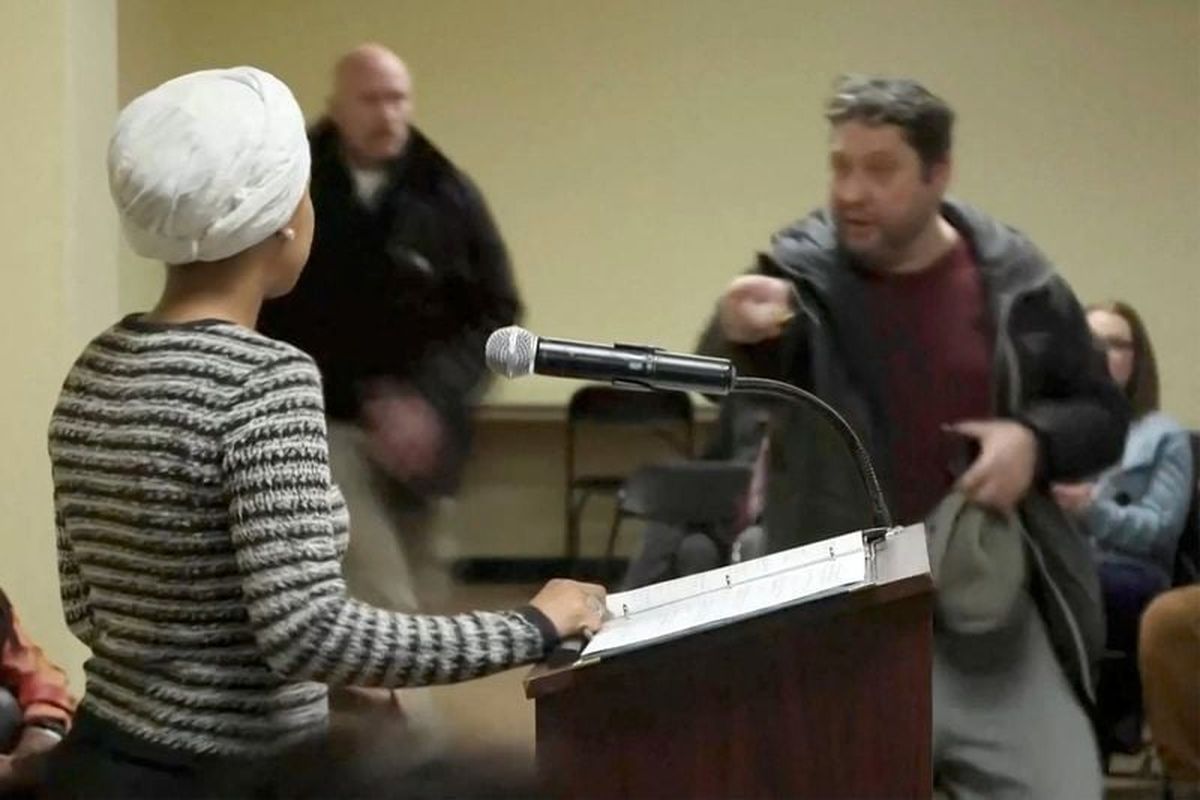 A man shouts at U.S. Rep. Ilhan Omar (D-Minn.) after spraying her Tuesday during a town hall meeting days after a man identified as Alex Pretti was fatally shot by federal immigration agents trying to detain him, in Minneapolis.  (Maria Alejandra Cardona)