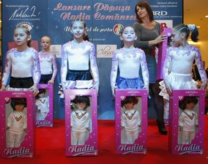 Former Romanian gymnastics star Nadia Comaneci walks behind young athletes during the launch of a doll named after her in Bucharest, Romania, Sunday, Dec. 6, 2009. A part of the money from the sales of the toy will be donated to Romanian gymnastics clubs to support talented children. (Vadim Ghirda / Associated Press)