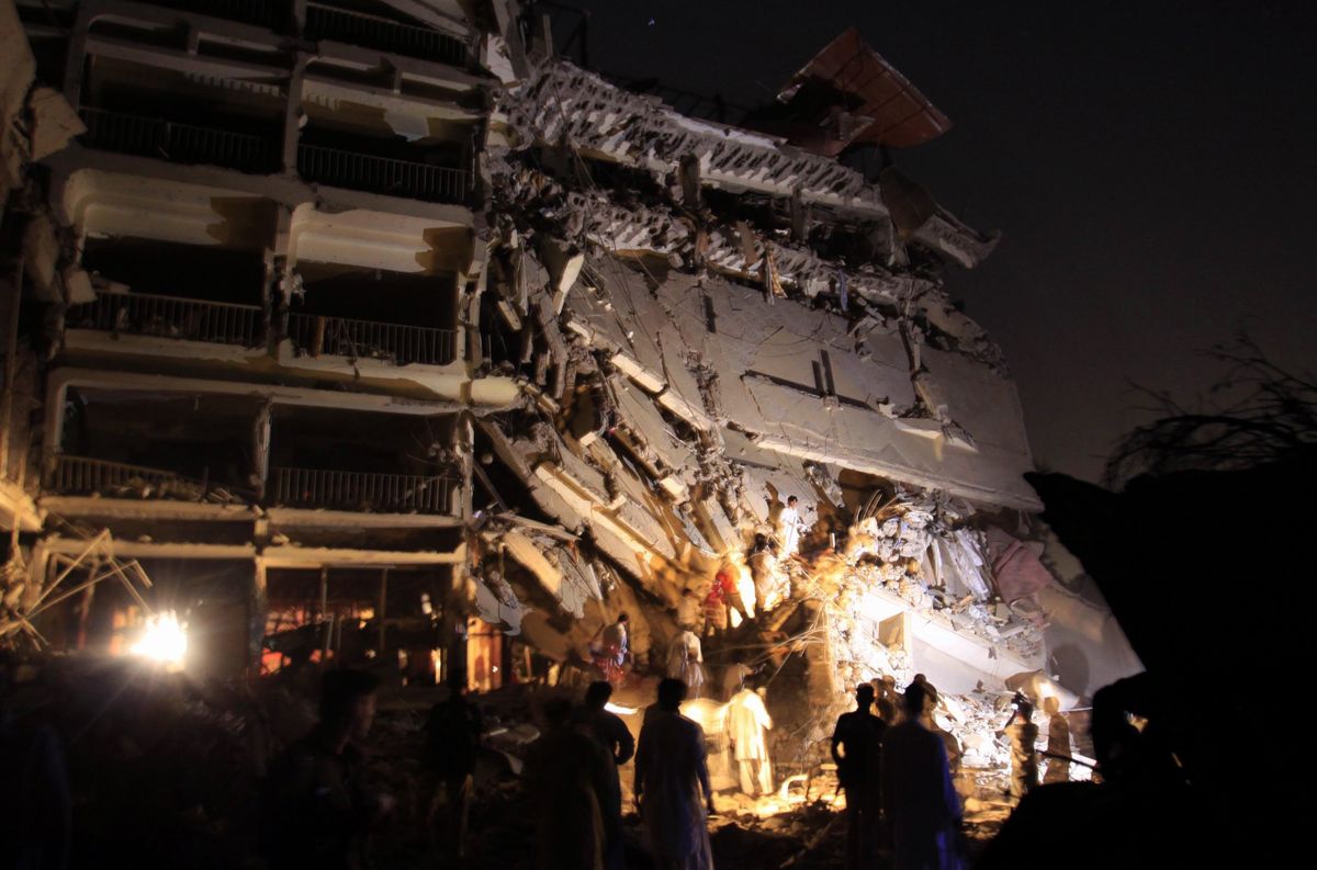 Pakistani rescue members search for victims among the rubble of a partially collapsed hotel after an explosion in Peshawar, Pakistan, on Tuesday, (Mohammad Sajjad / The Spokesman-Review)