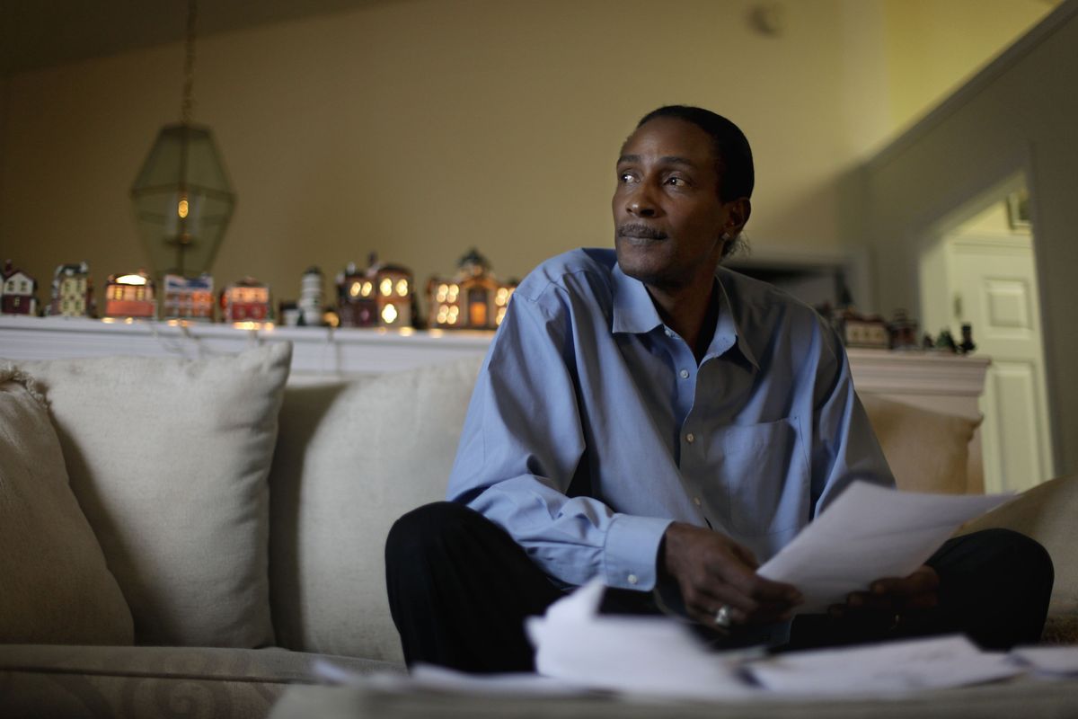 Wayne Pittman, 46, sits in his Lawrenceville, Ga., home looking over unemployment papers as his extended benefits are set to expire unless Congress passes a vote to extend them.  (Associated Press)