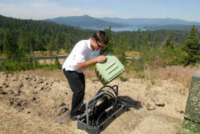 
Jake Zachman, of CSK Communications, lifts the cover of a utility box that is part of the Internet and satellite TV system infrastructure that CSK installed to service Gozzer Ranch, a development on Lake Coeur d'Alene. CSK enables rural communities to have the same technology services available to urban dwellers. 
 (Jesse Tinsley / The Spokesman-Review)