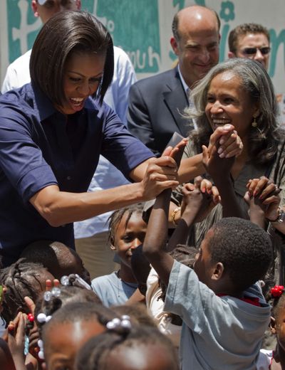 First lady Michelle Obama and Haiti’s first lady Elisabeth Delatour Preval greet children at a center for displaced children in Port-au-Prince on Tuesday.  (Associated Press)