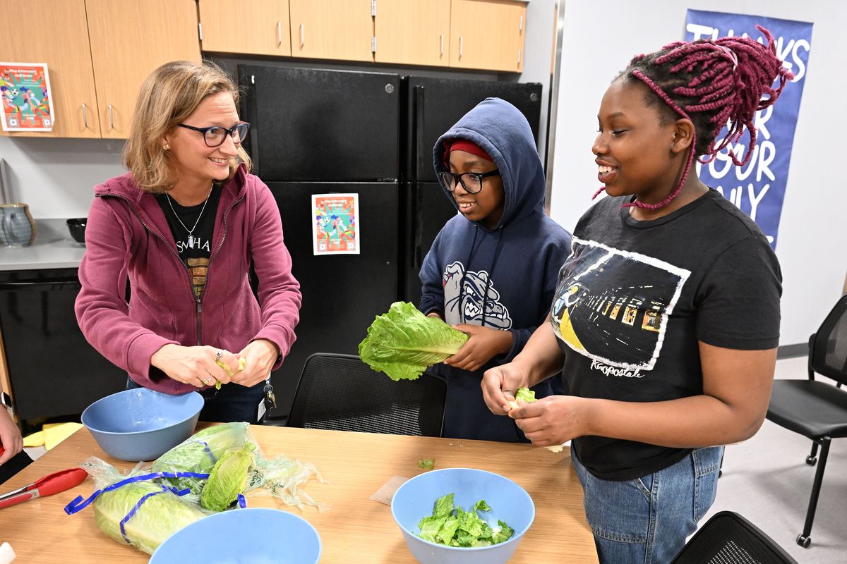 Sacajawea Cooking Club adviser Adrienne Wade, left, an English and Drama teacher at the middle school, helps students Phoebe Ushindi, 11, and Janet Ortance, 14, make a Cobb salad on May 20.  (COLIN MULVANY/THE SPOKESMAN-REVIEW)