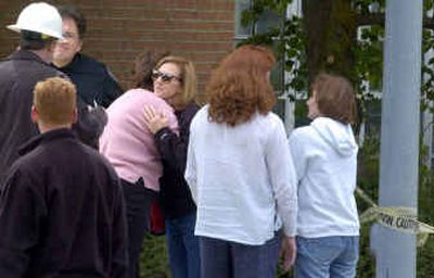 The family of Mike Cmos, including his sister, Frances Papenleur (in sunglasses), and staff of the plant embrace after his body was recovered from the holding tank.
(Christopher Anderson/The Spkesman-Review / The Spokesman-Review)